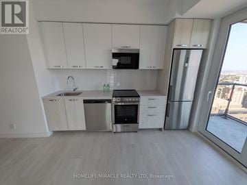 Hamilton (Corktown) condo for rent - A kitchen with white cabinets and stainless steel appliances.