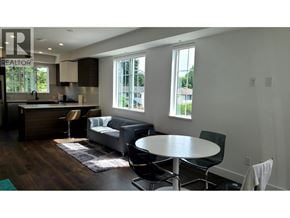 Richmond townhouse for rent - A modern living room with a kitchen area in the background.