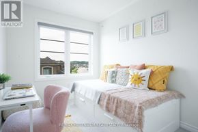 Milton (Cb Cobban) townhouse for rent - A bright bedroom with a bed, chair, and window.
