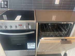 Toronto (Cabbagetown-South St. James Town) condo for rent - A stainless steel oven with a digital display and knobs is on the left, and an empty wooden oven drawer is on the right.