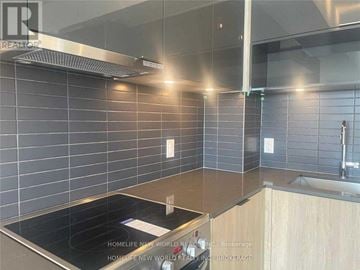 Toronto (Cabbagetown-South St. James Town) condo for rent - A modern kitchen with a stove top oven and wooden cabinets.