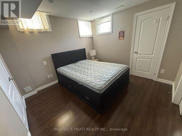 Newmarket (Woodland Hill) apartment for rent - A bedroom with a large bed and wooden floors.