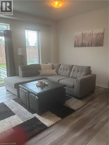 Woodstock townhouse for rent - A living room with a grey couch and a black and white rug.