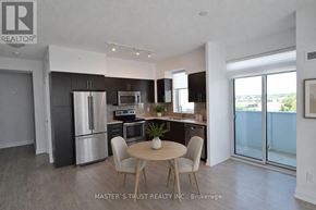 Oakville (Co Central) condo for rent - A kitchen with a table and chairs in the middle of the room.