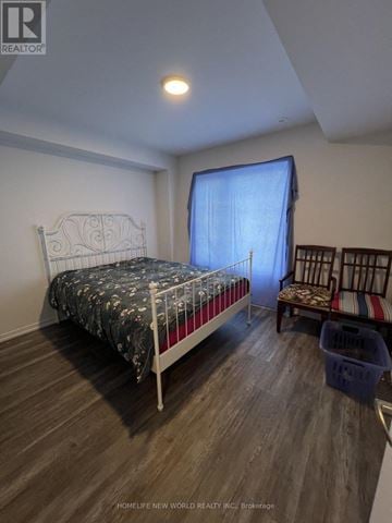 Richmond Hill apartment for rent - A bedroom with a white bed and a chair with a striped cushion.