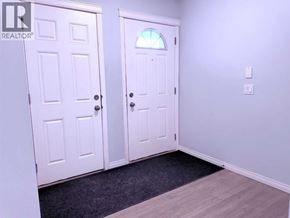 Calgary apartment for rent - A hallway with two doors and a carpeted floor.