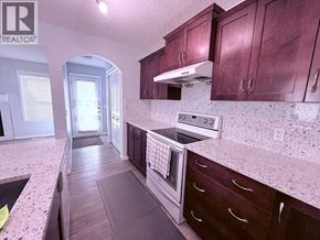 Calgary apartment for rent - A kitchen with a pink counter top and wooden cabinets.