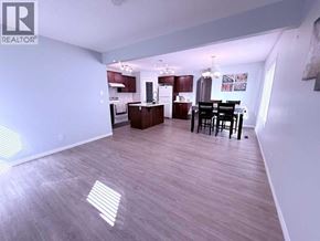 Calgary apartment for rent - A well-lit open plan kitchen and dining area with wooden flooring.