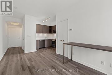 Toronto (Niagara) condo for rent - A spacious room with a kitchenette and a bar area.
