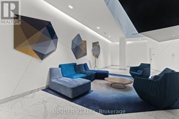 Toronto (Niagara) condo for rent - A modern living room with a blue couch and geometric wall art.
