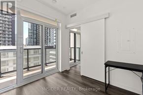 Toronto (Niagara) condo for rent - A room with a table and a window overlooking a cityscape.