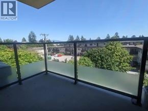 Burnaby apartment for rent - A balcony with a glass railing overlooks a residential area.