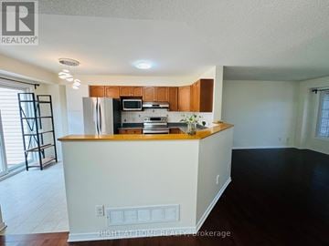 Ottawa townhouse for rent - A kitchen with white cabinets and a wooden countertop.