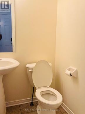 Ottawa townhouse for rent - A white toilet in a bathroom with a sink to the left.