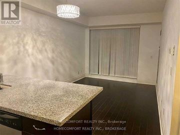 Markham (Unionville) condo for rent - A kitchen with a granite countertop and a dining area with a table and chairs.