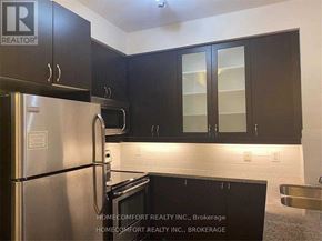 Markham (Unionville) condo for rent - A kitchen with a refrigerator, microwave, and cabinets.