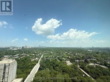 Toronto (North St. James Town) condo for rent - A real estate company logo is on a picture of a cityscape.