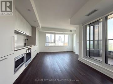 Toronto (North St. James Town) condo for rent - A spacious kitchen with white cabinets and a large window.
