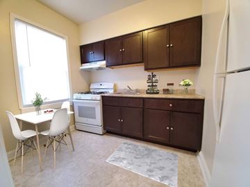 Hyattsville apartment for rent - A kitchen with brown cabinets and a white fridge.