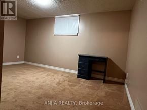 Mississauga (Erindale) apartment for rent - A room with beige walls and carpeting, a window, and a black dresser.