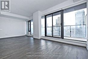 Toronto (Church-Yonge Corridor) condo for rent - A spacious room with a view of the city through large windows.