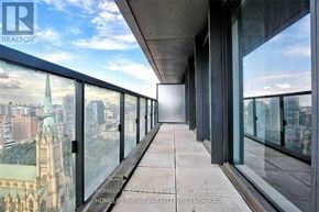 Toronto (Church-Yonge Corridor) condo for rent - A balcony with glass doors overlooking a cityscape.