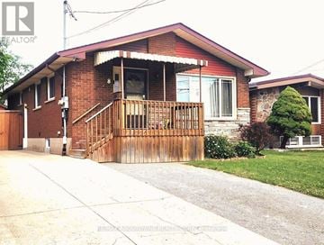 Hamilton (Greeningdon) duplex for rent - A red brick house with a wooden fence and a small tree in front.