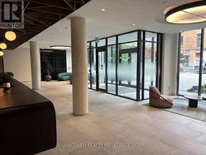 Toronto (Niagara) condo for rent - A modern office lobby with a reception desk and a view of the city.