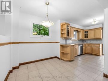Pickering (Amberlea) apartment for rent - A kitchen with wooden cabinets and a window showing trees outside.