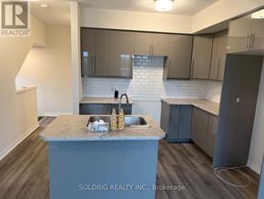 Brantford townhouse for rent - A kitchen with a marble island and grey cabinets.