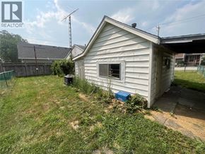 Wallaceburg apartment for rent - A small house with a fence and a blue box in front of it.