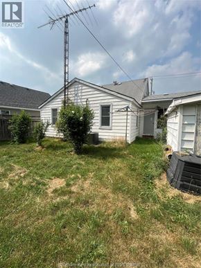 Wallaceburg apartment for rent - A house with a yard and a tall antenna on the roof.