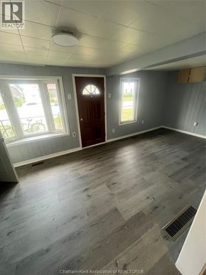 Wallaceburg apartment for rent - A room with a wooden floor and a brown door.