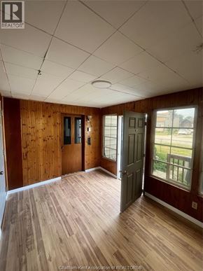 Wallaceburg apartment for rent - A room with wooden walls and floors, a ceiling with lights, and a door leading outside.