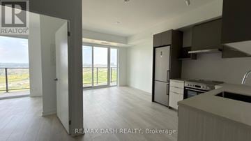 Vaughan (Steeles West Industrial) condo for rent - A kitchen with a refrigerator, stove, and sink is shown in a modern open space.