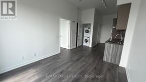 Vaughan (Steeles West Industrial) condo for rent - A room with a wooden floor and a wall with a RE/MAX Dash Realty logo.