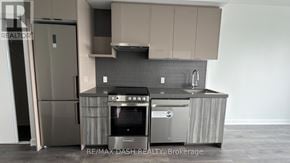Vaughan (Steeles West Industrial) condo for rent - A modern kitchen with a stainless steel refrigerator and oven.