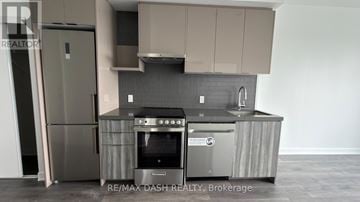 Vaughan (Steeles West Industrial) condo for rent - A modern kitchen with a stainless steel refrigerator and oven.