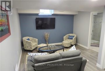 Welland (Coyle Creek) townhouse for rent - A living room with a grey couch and a round table.