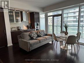 Toronto (Waterfront Communities) condo for rent - A modern living room with a grey couch and a dining table.