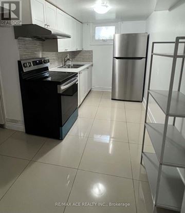 Toronto (West Hill) apartment for rent - A kitchen with a black stove top oven and a silver refrigerator.