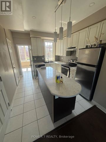 Toronto (West Hill) townhouse for rent - A kitchen with a black refrigerator and a white countertop.