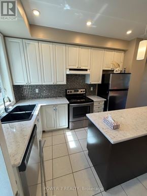 Toronto (West Hill) townhouse for rent - A kitchen with white cabinets and black appliances.