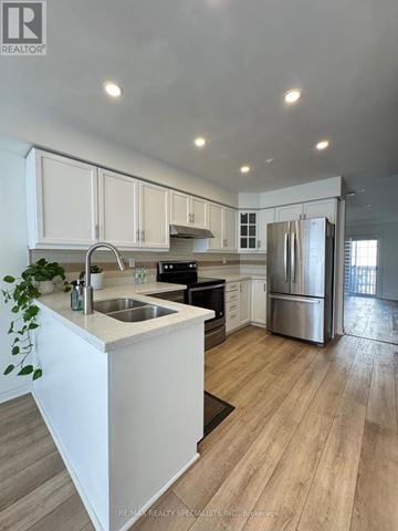 Burlington (Palmer) townhouse for rent - A modern kitchen with white cabinets and stainless steel appliances.