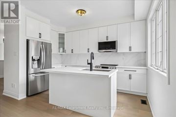 Oakville (Wm Westmount) townhouse for rent - A white kitchen with a sink and a refrigerator.