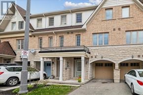 Oakville (Wm Westmount) townhouse for rent - A two-story brick house with a garage and a car parked in front.