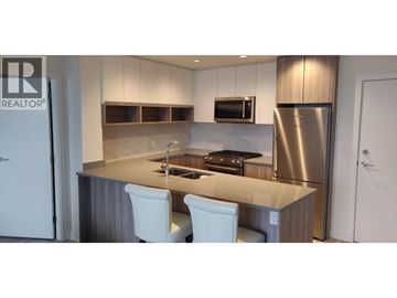 Burnaby apartment for rent - A modern kitchen with a stainless steel refrigerator and white chairs.