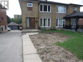Toronto (Brookhaven-Amesbury) apartment for rent - A brick house with a brown door and a small front yard.