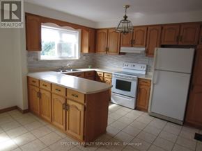 Toronto (Brookhaven-Amesbury) apartment for rent - A kitchen with wooden cabinets and a white refrigerator.