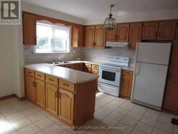 Toronto (Brookhaven-Amesbury) apartment for rent - A kitchen with wooden cabinets and a white refrigerator.